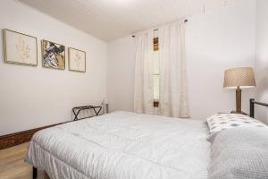 een witte slaapkamer met een bed en een raam bij Mountain Serene Views and Creek-side Charm - Pet friendly 