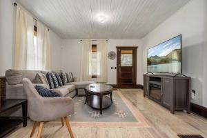 een woonkamer met een bank en een tv bij Mountain Serene Views and Creek-side Charm - Pet friendly 