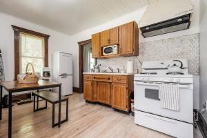 een keuken met witte apparatuur en een houten vloer bij Mountain Serene Views and Creek-side Charm - Pet friendly 