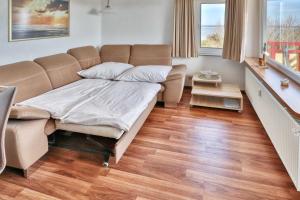 a living room with a bed and a couch at Terrassenhaus, FeWo 88 in Duhnen