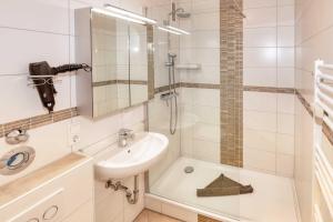 a bathroom with a sink and a shower at Terrassenhaus, FeWo 88 in Duhnen +13 photos
