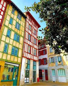 a group of buildings with red and yellow at La Grange Climatisé in Bayonne