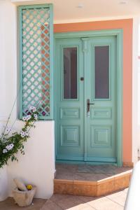 a green door on a house with a white wall at Secret Heaven in Agia Marina