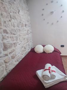 a bedroom with a bed with towels and a brick wall at La casa nel vico in Molfetta
