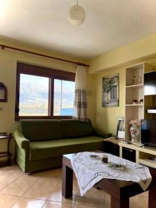 salon z zieloną kanapą i stołem w obiekcie Blue Guesthouse w Gjirokastrze