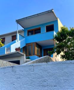 una casa azul en la parte superior de una pared de piedra en Blue Guesthouse en Gjirokastër