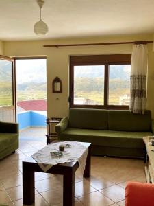 sala de estar con sofá verde y mesa en Blue Guesthouse, en Gjirokastra