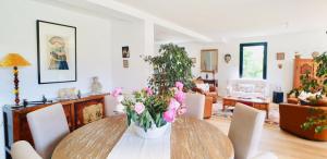 jadalnia ze stołem i różowymi kwiatami w obiekcie Superbe Villa 2 min Plage de Banastère avec Grand Jardin Terrasse Piano Solarium Presqu'île de Rhuys w mieście Sarzeau