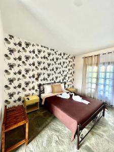 a bedroom with a large bed with a wall covered in butterflies at Blue Garden Inn in Fourka