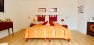 sypialnia z łóżkiem z czerwonymi poduszkami w obiekcie Superbe Villa 2 min Plage de Banastère avec Grand Jardin Terrasse Piano Solarium Presqu'île de Rhuys w mieście Sarzeau