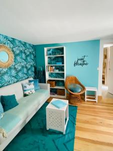 a living room with a couch and a blue wall at CASA BOHO your happy place in Calheta in Calheta +62 photos