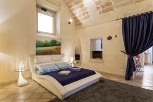 レッチェにあるSuite Paisielloのベッドルーム1室(ベッド1台付)が備わります。壁には絵画が飾られています。