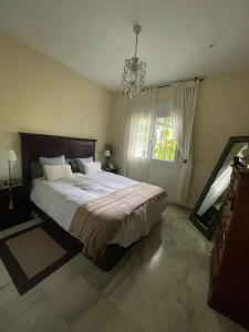 a bedroom with a large bed and a chandelier at Golden Beach in Marbella