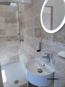ein Bad mit einem Waschbecken und einem Spiegel in der Unterkunft Hôtel Beauséjour Logis de France in Berre-des-Alpes
