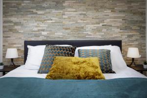 uma cama com duas almofadas e uma parede de tijolos em Seaside Suite 1 - Beautiful Long Stay Studio on Lord Street em Blackpool
