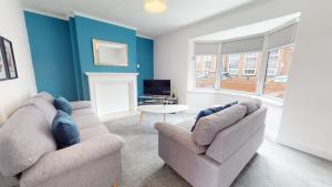 Sala de estar con 2 sofás y mesa en Stratford House Hartlepool Horizon Stays, en Hartlepool