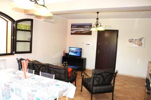 a dining room with a table and chairs and a television at Casa Vacanze A Ravà in Francavilla di Sicilia