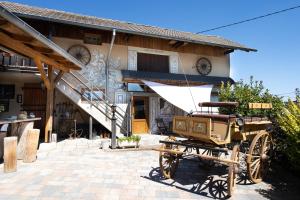 un chariot à l'extérieur d'une maison avec un bâtiment dans l'établissement Maison d'hôtes du Mont, à Morschwiller