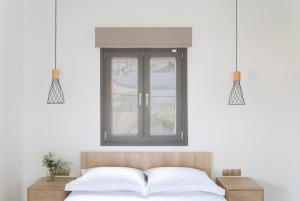 a bedroom with a window and a bed with white sheets at Green Hill Thassos in Skala Potamias