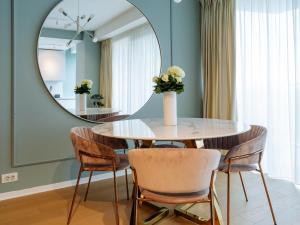 a dining room with a round mirror and a table and chairs at The Heights of Sophistication - Panoramic Views in Bucharest