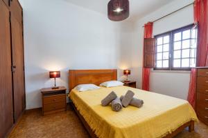 a bedroom with a yellow bed with two towels on it at Apartamentos Capitão by Umbral in Porto Covo