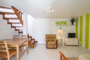 uma sala de estar com uma mesa e uma cadeira e escadas em Apartamentos Capitão by Umbral em Porto Covo