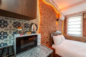 Un dormitorio con una cama y una pared de ladrillo. en Blue Sea Apart Hotel, en Estambul