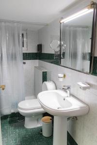 a bathroom with a sink and a toilet and a mirror at Cozy Central Home Heraklion in Heraklio +20 photos