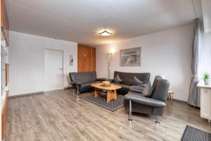 a living room with a couch and chairs and a table at Terrassenhaus, FeWo 55 in Duhnen