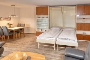 a room with a bed and a table and a dining room at Terrassenhaus, FeWo 55 in Duhnen