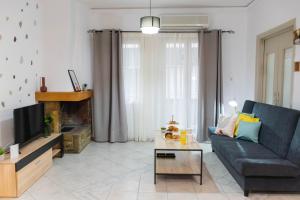 a living room with a couch and a tv at Cozy Central Home Heraklion in Heraklio Town