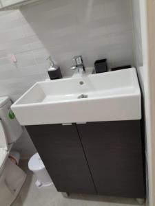 La salle de bains est pourvue d'un lavabo blanc et de toilettes. dans l'établissement Bel appartement meublé à Temara 10 minutes de la plage et 15 minutes du stade Prince Moulay Abdellah, à Oulad Kerroum