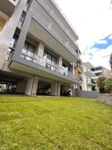 a large building with a lawn in front of it at Imperial Suites Ioannina in Ioannina