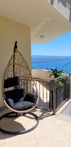einen Hängesessel auf einem Balkon mit Meerblick in der Unterkunft Casa Panorama Lovran - Sea View Apartment NEW! in Lovran