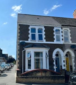 een bruin bakstenen huis met een witte voordeur bij Habershon by Switchback Stays in Cardiff