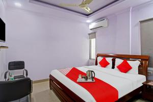 a bedroom with a bed with red and white pillows at OYO Flagship Dreamy Sunrise By Stayapart Near City Centre Salt Lake in Kolkata