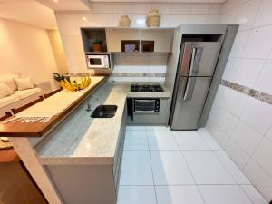a small kitchen with a stove and a refrigerator at Acoara Beco Doce in Jericoacoara