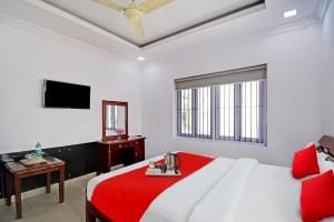 a bedroom with a large bed with a red blanket at OYO Flagship Dreamy Sunrise By Stayapart Near City Centre Salt Lake in Kolkata