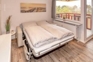 ドゥネンにあるTerrassenhaus, FeWo 45の窓付きの部屋の病院用ベッド