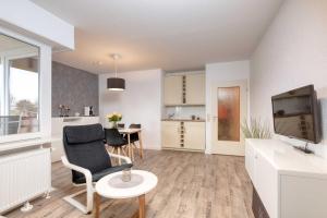 ドゥネンにあるTerrassenhaus, FeWo 45のリビングルーム(椅子、テレビ付)