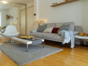 a living room with a couch and a table at Bright One-Bedroom Condo with Modern Amenities in Bucharest
