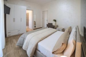 - une grande chambre blanche avec un grand lit et un bureau dans l'établissement GREEN - Bed and Breakfast a Castrovillari, à Castrovillari