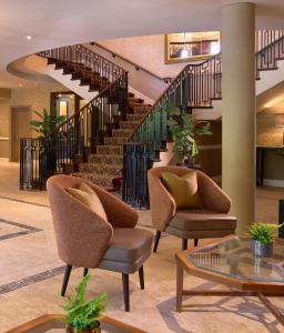 a lobby with two chairs and a staircase at Tulfarris Hotel and Golf Resort in Blessington