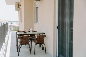 balcone con tavolo e sedie neri di Apartments Christina a Perdika