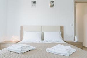 2 asciugamani posti sopra un letto di Apartments Christina a Perdika