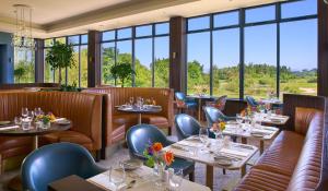 een restaurant met tafels, stoelen en ramen bij Tulfarris Hotel and Golf Resort in Blessington