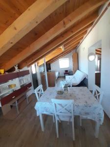 a dining room with a table and chairs in a room at Apartman Kolona in Tkon