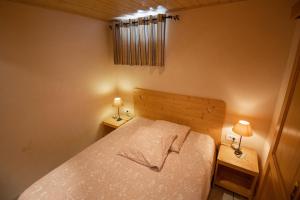 a small bedroom with a bed and two night stands at Maison d'hôtes du Mont in Morschwiller