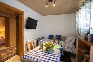 a living room with a table and a couch at Maison d'hôtes du Mont in Morschwiller