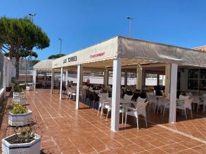 un ristorante con tavoli e sedie sotto una tenda di Duplex Las Torres La Barrosa 3Beds - A 700m de la playa a Chiclana de la Frontera